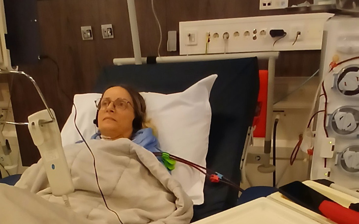 Kobieta leżąca w łóżku szpitalnym z aparaturą medyczną.