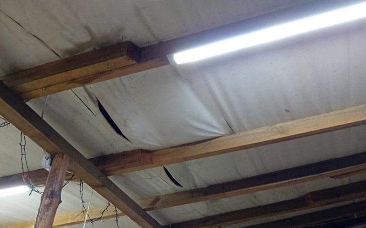 Uszkodzone sufity w pomieszczeniu, widoczne pęknięcia.