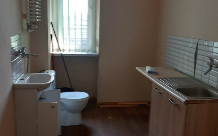 Pusty pokój z kuchnią i toaletą.