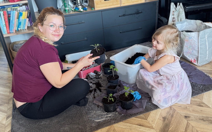 Mama z dzieckiem sadzące rośliny w doniczkach.