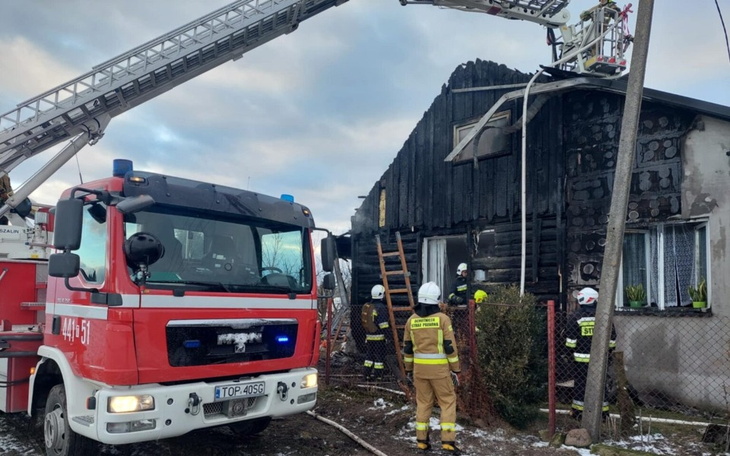 Strażacy gaszą pożar w zniszczonym budynku.
