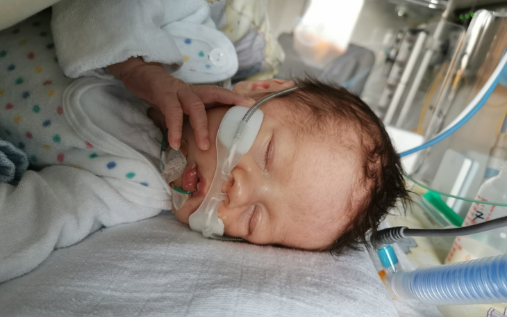 Noworodek w inkubatorze z rurką tlenową.