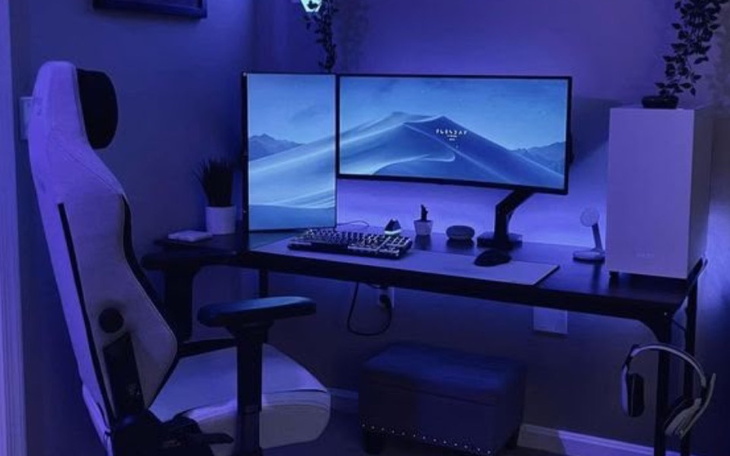 Nowoczesne biurko z dwoma monitorami w niebieskim świetle.