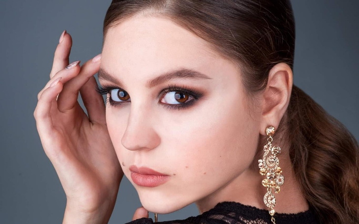Portret dziewczyny z makijażem i biżuterią.