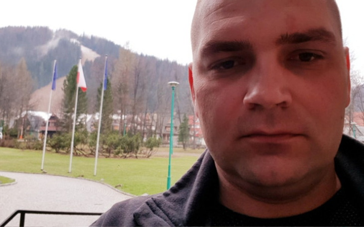 Mężczyzna w niebieskim ubraniu, pracujący z zwierzętami.