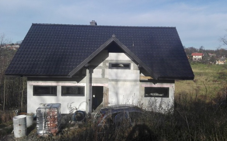 Budowa domu w malowniczej okolicy, z nowym dachem i oknami.