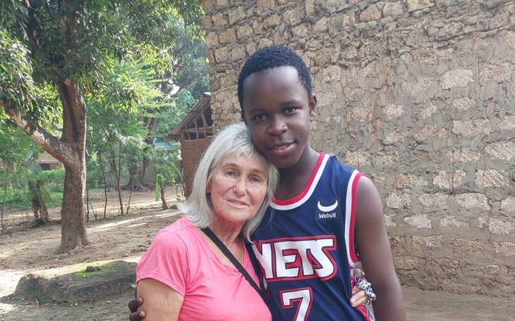 Kobieta przytulająca młodego chłopca w plenerze.