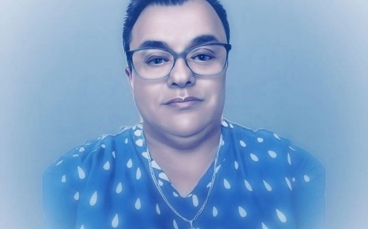 Portret osoby w okularach, w niebieskiej koszuli z kropkami.