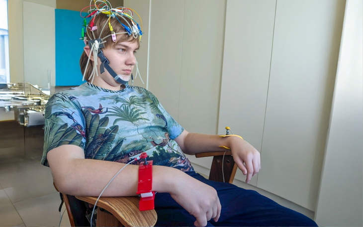 Młody mężczyzna z elektrodami na głowie, w skupieniu.