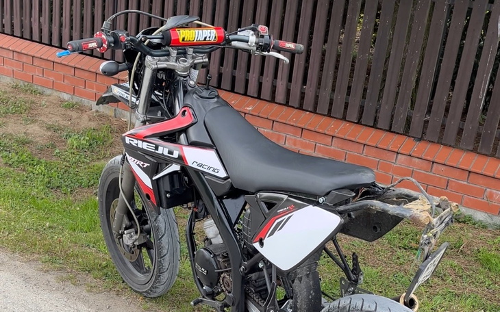 Motocykl Rieju zaparkowany na trawie.