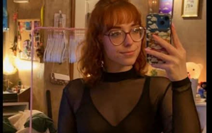 Młoda kobieta robiąca selfie w przezroczystej bluzce.