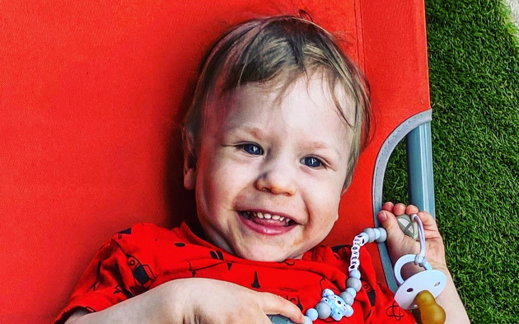 Uśmiechnięty chłopiec bawiący się na leżaku, pełen radości.