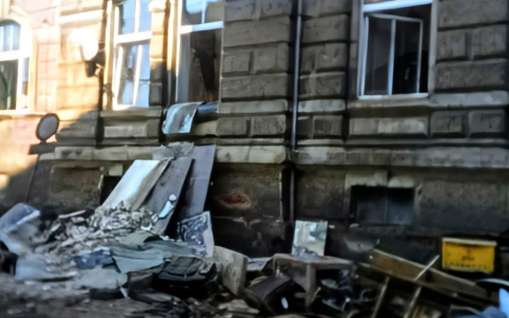 Zniszczony budynek z gruzem i odpadkami na zewnątrz.