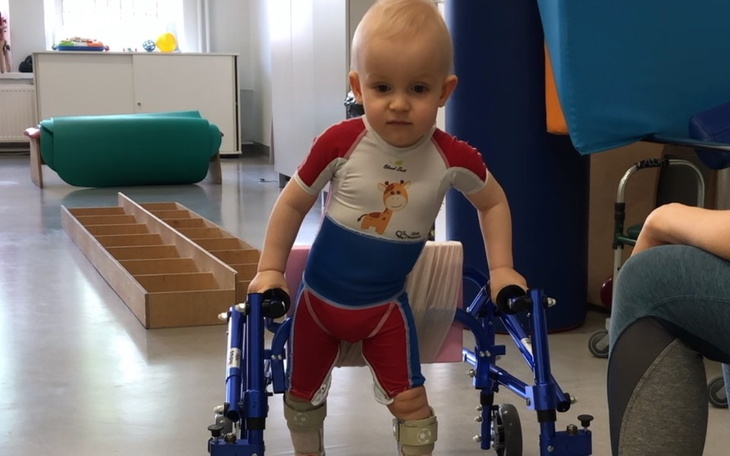 Małe dziecko korzystające z chodzika w rehabilitacji.