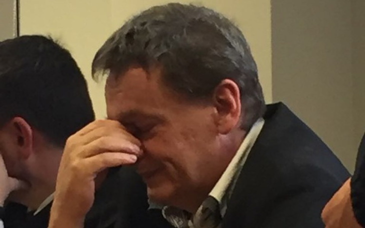 Mężczyzna z ręką na twarzy, wyrażający emocje.