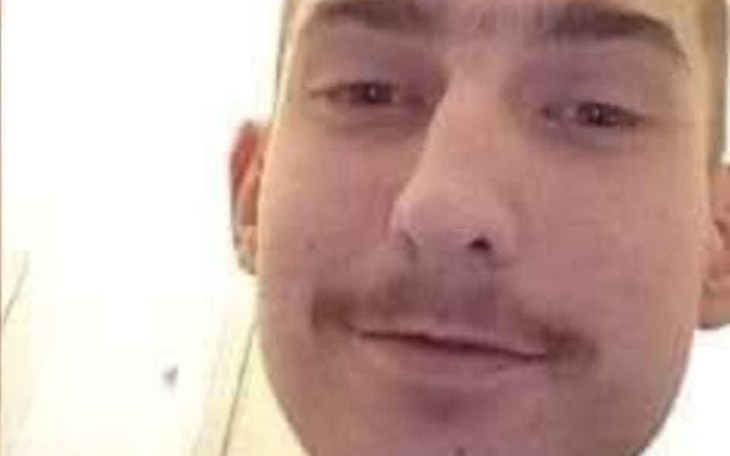 Mężczyzna z wąsami, uśmiechający się do kamery.