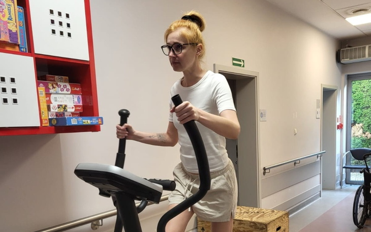 Kobieta ćwiczy na urządzeniu fitness w rehabilitacji.