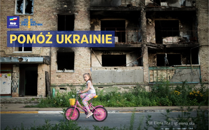 Dziewczynka na różowym rowerze w zniszczonej okolicy.