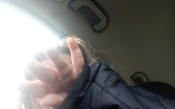 Zamazana fotografia osoby, ręka zasłaniająca obiektyw.