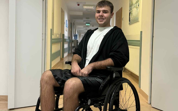 Młody mężczyzna na wózku inwalidzkim, uśmiechnięty i pozytywny.