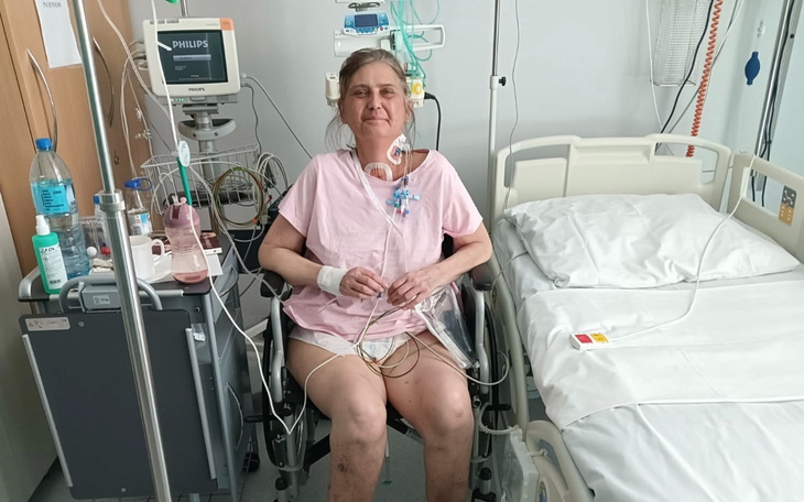 Kobieta w szpitalu, uśmiechająca się mimo trudnej sytuacji.