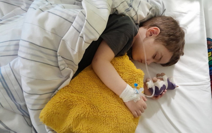 Chłopiec śpiący z pluszowym misiem, podłączony do aparatury.