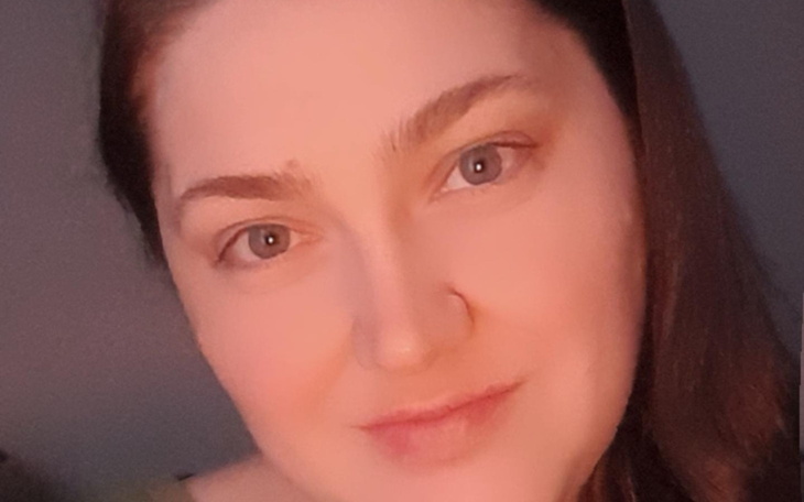 Kot leży na poduszce, wygląda na zrelaksowanego.