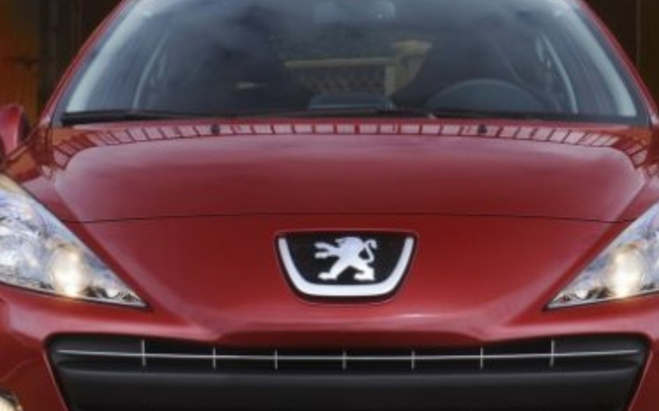 Czerwony samochód marki Peugeot, widok z przodu.