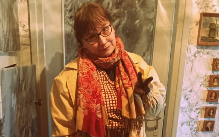 Kobieta w okularach, pozująca w stylowym płaszczu.