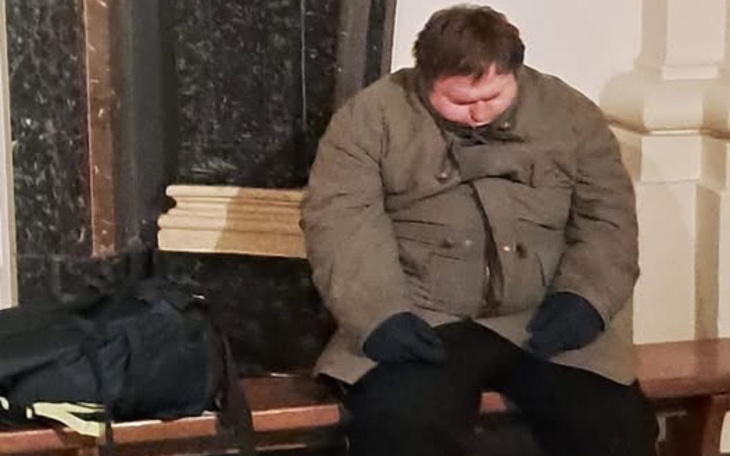 Mężczyzna siedzi na ławce, wygląda na zmęczonego.