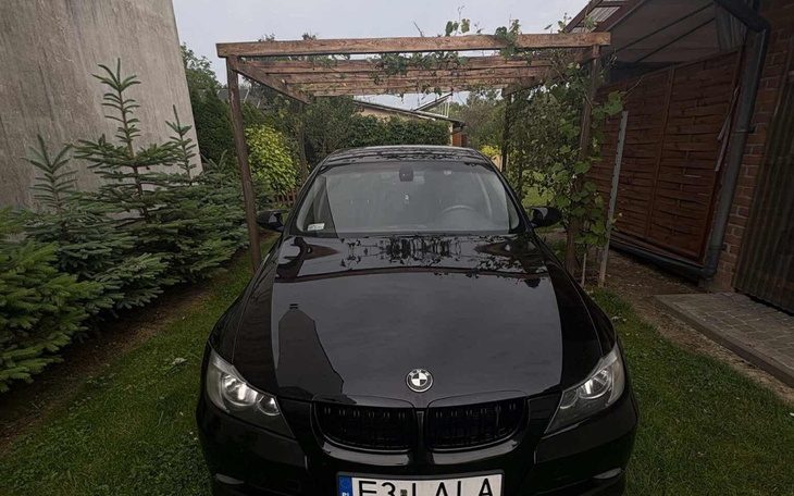 Dziecko bawiące się na trawie, uśmiechnięte i w kapeluszu.