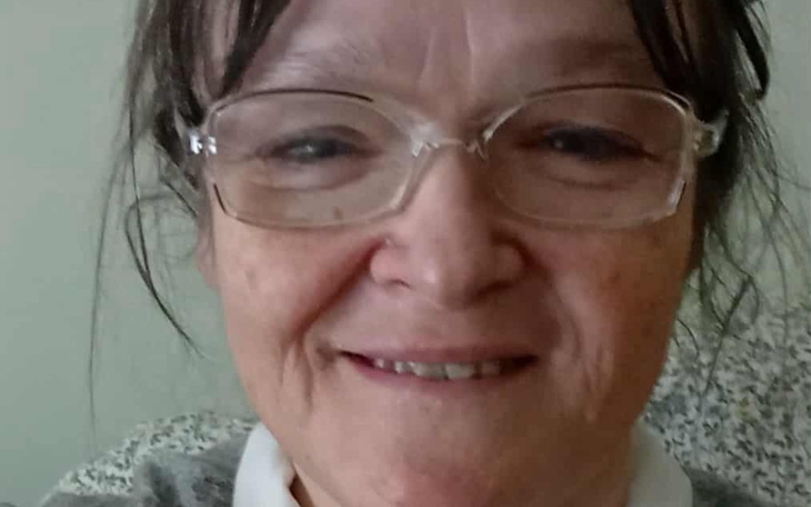 Uśmiechnięta starsza kobieta w okularach.