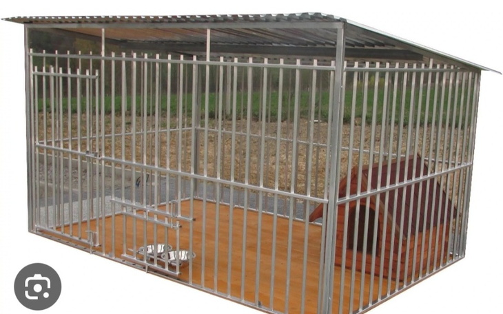 Klatka dla psów z metalowymi prętami i budą.