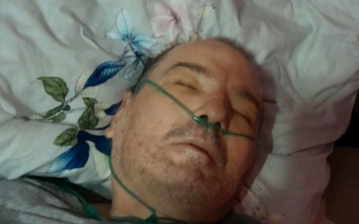 Mężczyzna leżący na poduszce, z tlenem na twarzy.