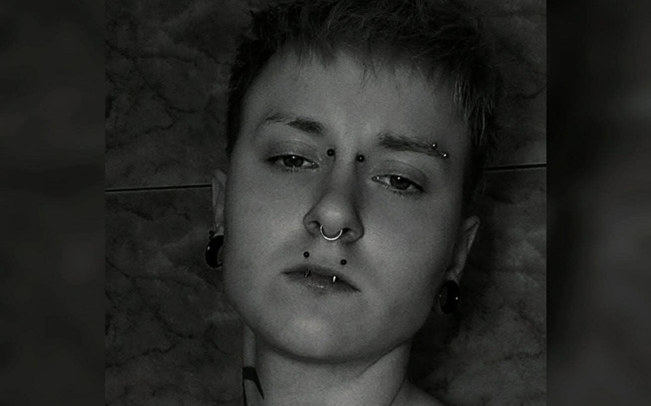 Portret osoby z kolczykami na twarzy.