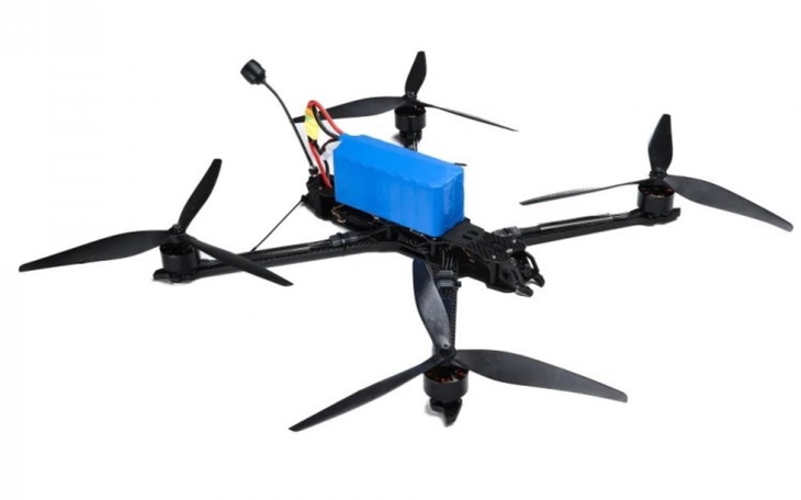 Dron z niebieskim akumulatorem, gotowy do lotu.