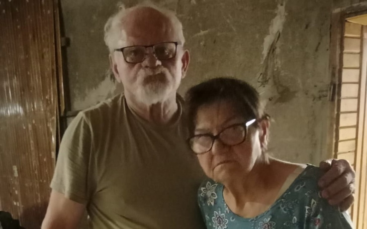 Starsza para pozująca do zdjęcia w domowym otoczeniu.