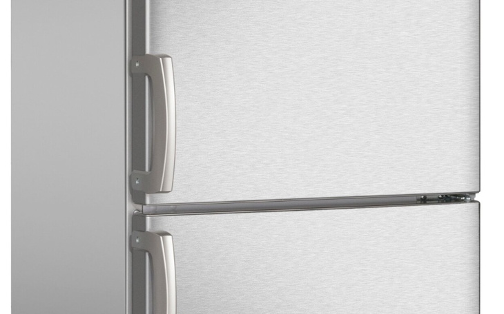 Nowoczesna lodówka w kolorze srebrnym, stojąca w kuchni.