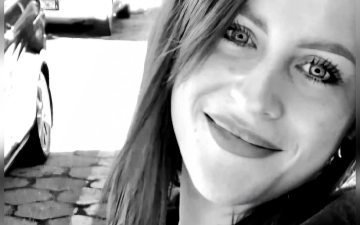 Uśmiechnięta kobieta w czarno-białym kadrze.