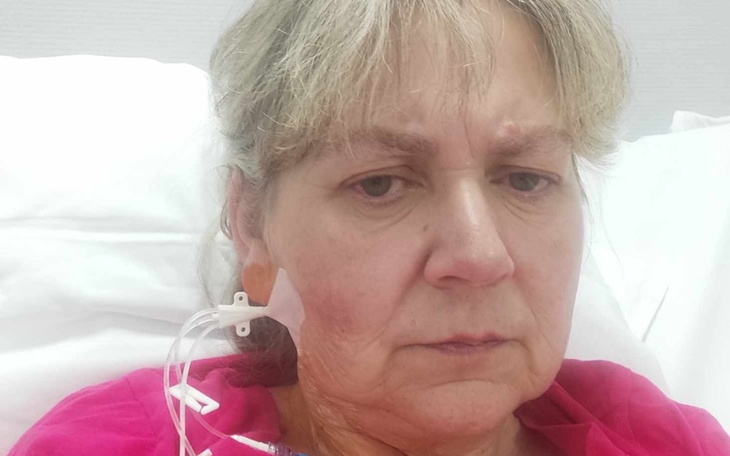 Kobieta w szpitalu z rurką tlenową przy uchu.