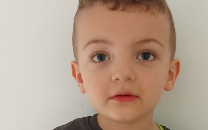 Portret małego chłopca z wyrazem twarzy pełnym ciekawości.