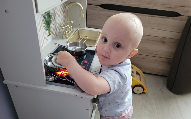 Małe dziecko bawi się w gotowanie w zabawkowej kuchni.