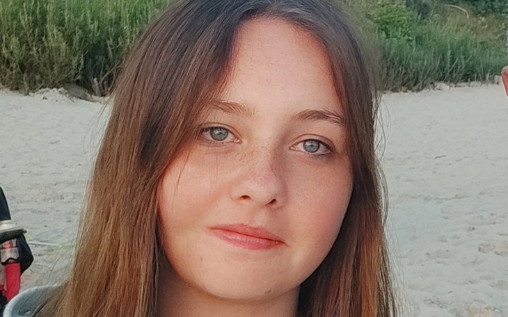 Młoda kobieta na plaży z uśmiechem.