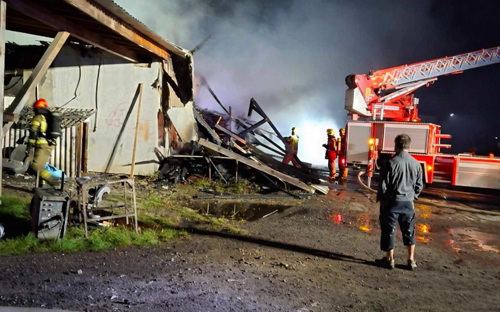 Strażacy gaszą pożar w zniszczonym budynku.