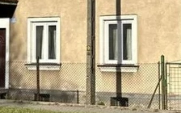 Widok na dom z oknami i ogrodzeniem.