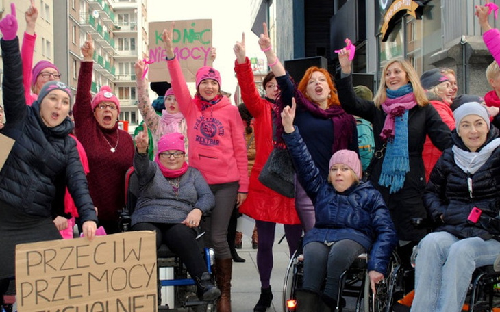 Kobiety w różowych czapkach, protestujące na ulicy.