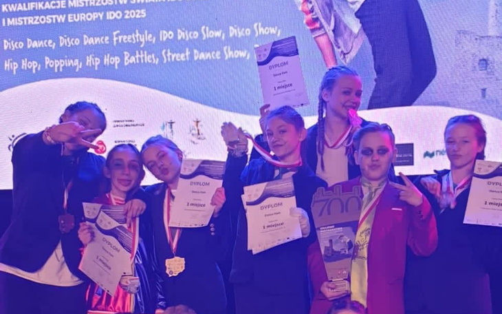 Grupa dzieci z dyplomami po zawodach tanecznych.