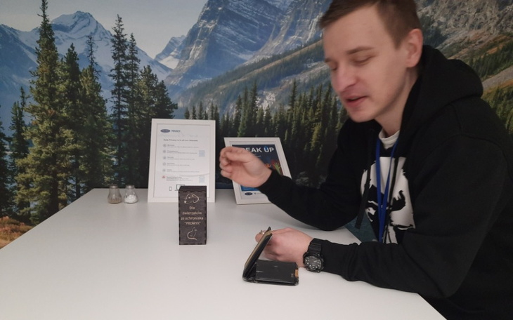 Mężczyzna przy stole, piszący na notatniku w biurze.