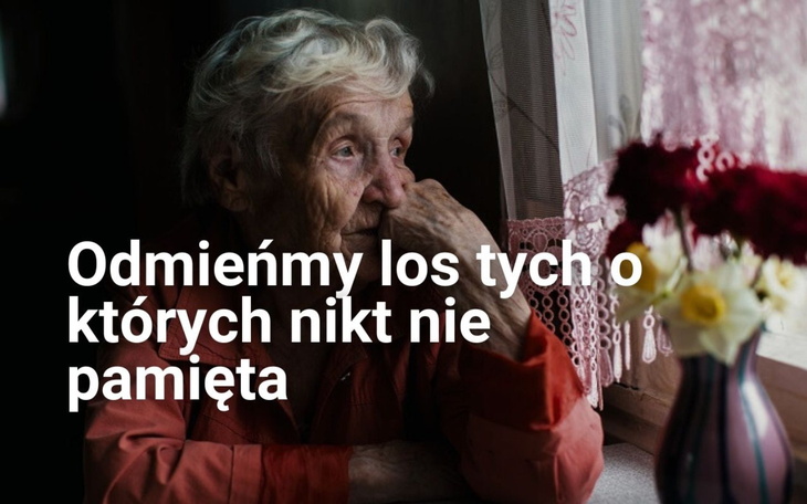 Starsza kobieta patrzy w dal, zamyślona.