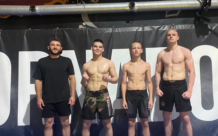 Czterech młodych zawodników MMA na treningu.